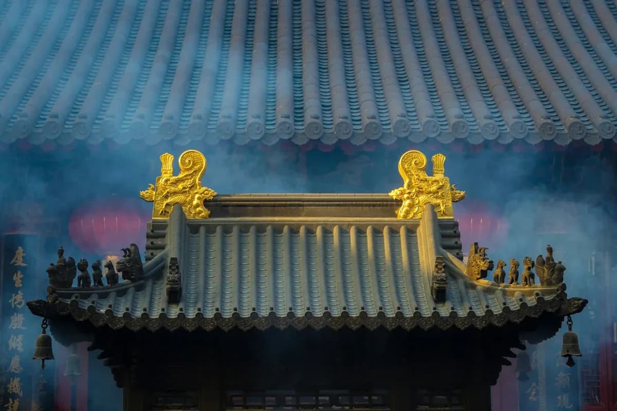 Golden dragon temple roof in incense smoke